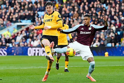 Wolverhampton Wanderers' Jorgen Strand Larsen, left, has a shot at goal past Aston Villa's Ezri Konsa, during the English Premier League soccer match between Aston Villa and Wolverhampton Wanderers, at Villa Park, in Birmingham, England.