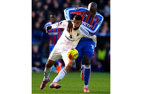 Manchester United's Noussair Mazraoui, left, and Crystal Palace's Jean-Philippe Mateta in action during the English Premier League soccer match between Crystal Palace and Manchester United in London.