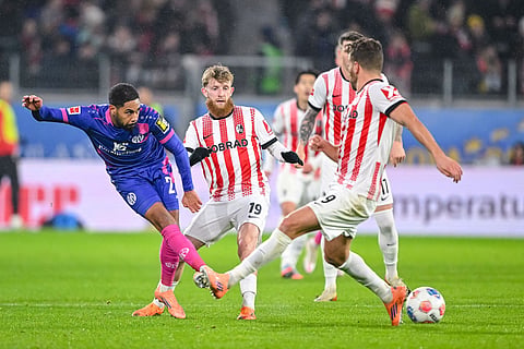 Phillipp Mwene of 1. FSV Mainz 05, left, vies for the ball withJan-Niklas Beste and Lucas Höler of SC Freiburg, during a German Bundesliga soccer match between SC Freiburg and 1. FSV Mainz 05, in Freiburg im Breisgau, Germany.