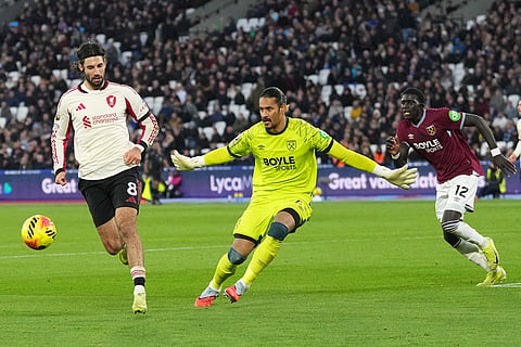 West Ham's goalkeeper Alphonse Areola, center, tries to close down Liverpool's Dominik Szoboszlai during the English Premier League soccer match between West Ham United and Liverpool, in London.