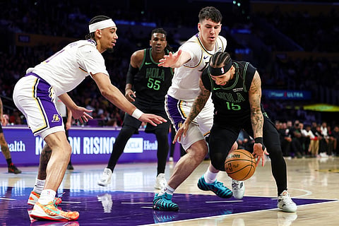 New Orleans Pelicans guard Jose Alvarado, right, drives against Los Angeles Lakers forward Jake LaRavia, second from right, as New Orleans Pelicans forward Kevon Looney (55) and Los Angeles Lakers center Jaxson Hayes, left, watch during the first half of an NBA basketball game in Los Angeles. 