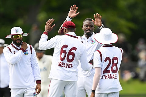 West Indies' bowler Jayden Seales, second right, celebrates with teammates after bowling New Zealand's Rachin Ravindra during their cricket test match in Christchurch, New Zealand.