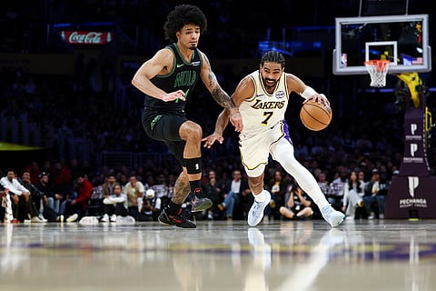 Los Angeles Lakers guard Gabe Vincent (7) drives against New Orleans Pelicans guard Micah Peavy, left, during the second half of an NBA basketball game in Los Angeles. 