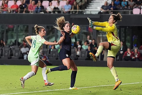 Italy goalkeeper Francesca Durante blocks a scoring attempt by United States forward Emma Sears, center, as Italy defender Martina Lenzini (19) defends during the second half of an international friendly soccer match in Fort Lauderdale, Fla.