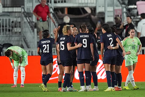 United States players celebrate their side's second goal, scored by midfielder Jaedyn Shaw, obscured, during the first half of an international friendly soccer match against Italy in Fort Lauderdale, Fla.