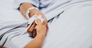 A patient holding a childs hand