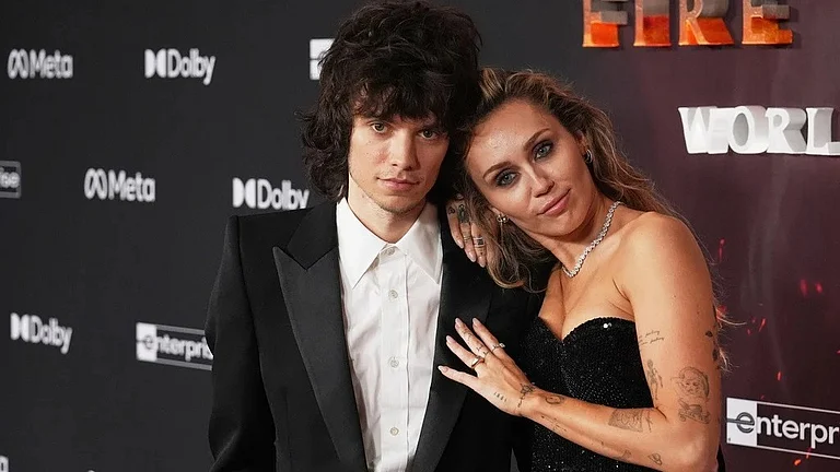 Singer Miley Cyrus, right, poses for photographers with her boyfriend Maxx Morando at the premiere of the film "Avatar: Fire and Ash" on Monday, Dec. 1, 2025, at Dolby Theatre in Los Angeles. - AP Photo/Chris Pizzello