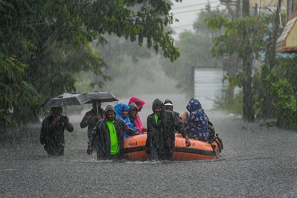 Photo: PTI/R Senthilkumar : People being rescued from a flood-affected area amid rainfall, in view of Cyclone Ditwah, in Chennai.