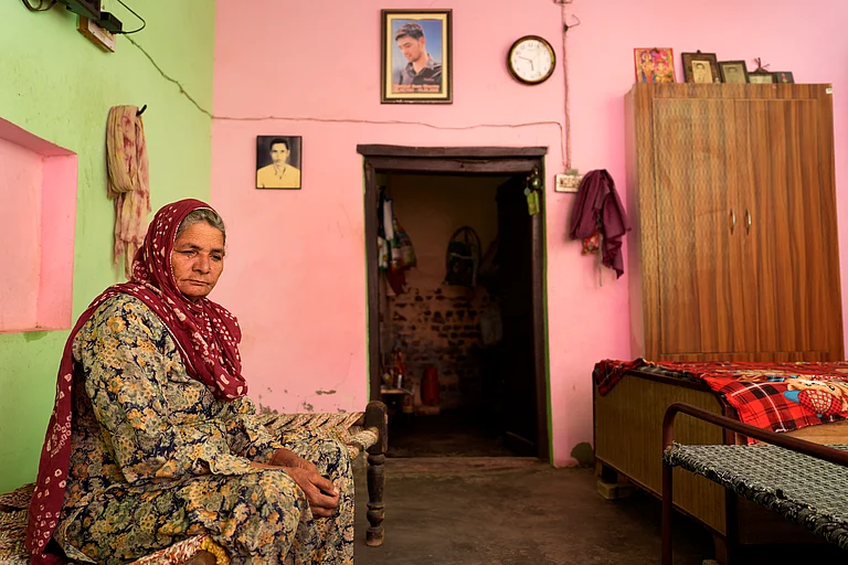 Sonu Kumar's mother sits in her house with the martyred photo of the her son on the wall. - SURESH K PANDEY
