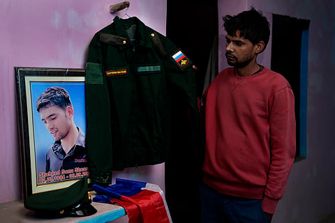 Vikas Kumar standing besides his brother Sonu's Russian Army uniform.