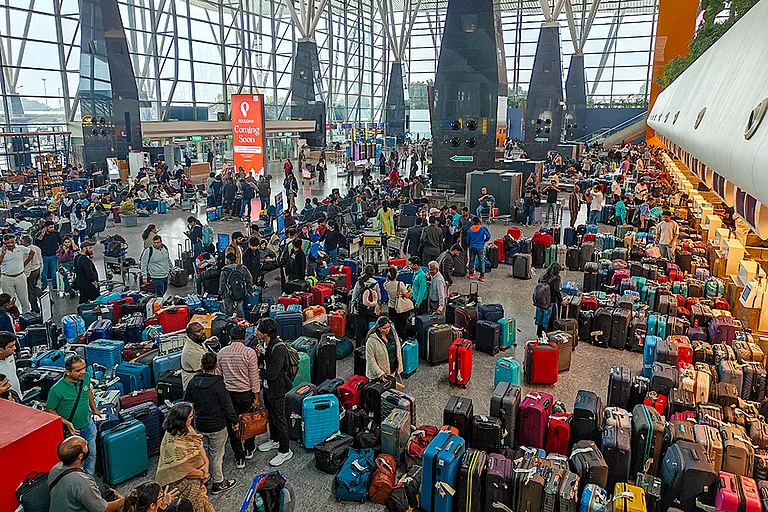 Stranded passengers search for their luggage near a counter after IndiGo cancelled more than 400 flights, at the Kempegowda International Airport, in Bengaluru, Karnataka. - | Photo: PTI/Shailendra Bhojak