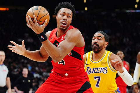 Toronto Raptors' Scottie Barnes (4) protects the ball from Los Angeles Lakers' Gabe Vincent (7) during first-half NBA basketball game action in Toronto, Thursday, Dec. 4, 2025. ()