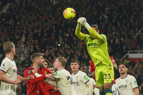 West Ham's goalkeeper Alphonse Areola punches the ball away during the English Premier League soccer match between Manchester United and West Ham United in Manchester, England.