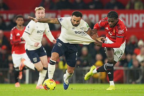 West Ham's Callum Wilson, center, challenges for the ball with Manchester United's Ayden Heaven during the English Premier League soccer match between Manchester United and West Ham United in Manchester, England.