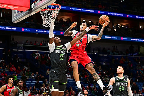 New Orleans Pelicans guard Jordan Hawkins, top right, attempts to score against Minnesota Timberwolves forward Jaden McDaniels (3) in the second half of an NBA basketball game in New Orleans.