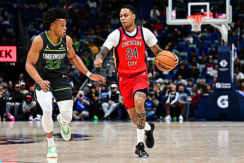 New Orleans Pelicans guard Jordan Hawkins (24) drives with the ball against Minnesota Timberwolves guard Jaylen Clark (22) in the second half of an NBA basketball game in New Orleans.