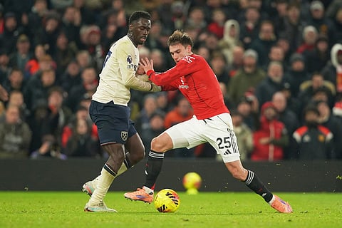 West Ham's Soungoutou Magassa, left, challenges for the ball with Manchester United's Manuel Ugarte during the English Premier League soccer match between Manchester United and West Ham United in Manchester, England.