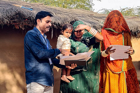 A booth level officer (BLO) assists voters in filling out enumeration forms for the special intensive revision (SIR) of electoral rolls, in Bikaner, Rajasthan.