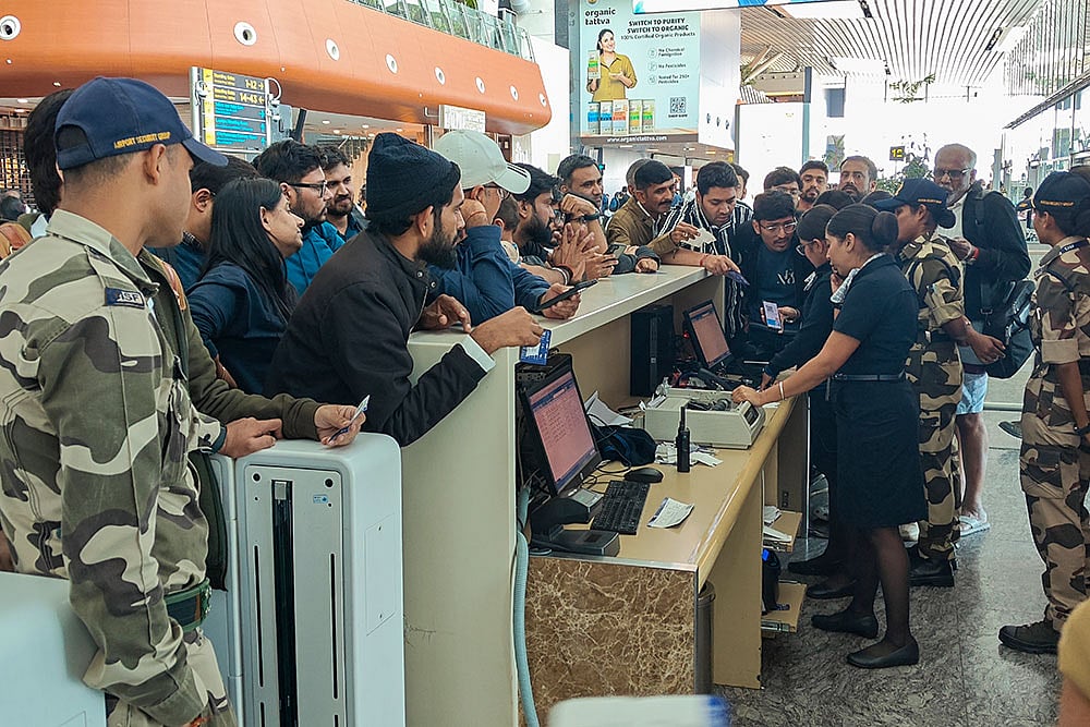 Photo: PTI/Shailendra Bhojak : Passengers enquire about their IndiGo flight at a boarding gate at Kempegowda International Airport amid flight disruptions, in Bengaluru. IndiGo's operations crumbled as pilot-rostering issues continued to force large scale flight cancellations -- over 400 on Friday -- and many passengers have been stranded for as long as three days at airports.