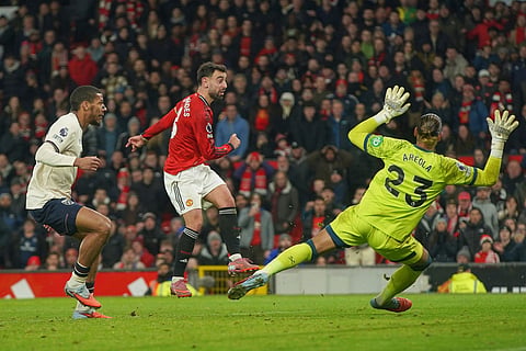 Manchester United's Bruno Fernandes, centre, makes an attempt to score past West Ham's goalkeeper Alphonse Areola, right, during the English Premier League soccer match between Manchester United and West Ham United in Manchester, England.
