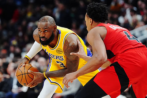 Los Angeles Lakers' LeBron James, left, is guarded by Toronto Raptors' Scottie Barnes (4) during second-half NBA basketball game action in Toronto.
