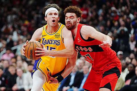Los Angeles Lakers' Austin Reaves, left, drives past Toronto Raptors' Jamison Battle (77) during second-half NBA basketball game action in Toronto.