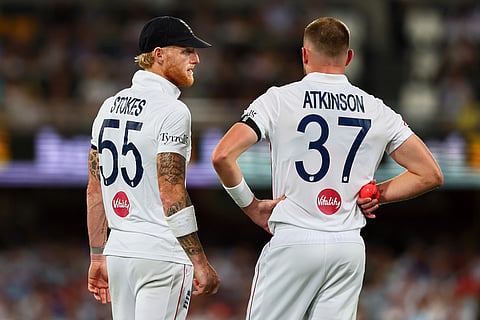 England's captain Ben Stokes speaks to England's Gus Atkinson before bowls a delivery during the second Ashes cricket test match between Australia and England in Brisbane.