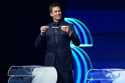 Former NFL player Tom Brady holds up the name of England during the draw for the 2026 soccer World Cup at the Kennedy Center in Washington.
