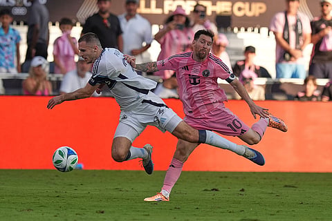 Inter Miami forward Lionel Messi (10) and Vancouver Whitecaps defender Joedrick Pupe (23) collide during the second half of the MLS Cup final soccer match in Fort Lauderdale, Fla.