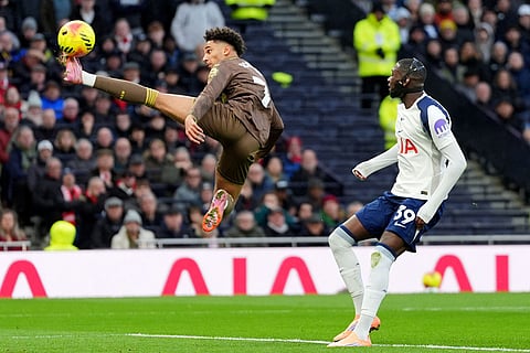 Brentford's Kevin Schade clears the ball, left, clears the ball during the English Premier League soccer match between Tottenham Hotspur and Brentford in London.
