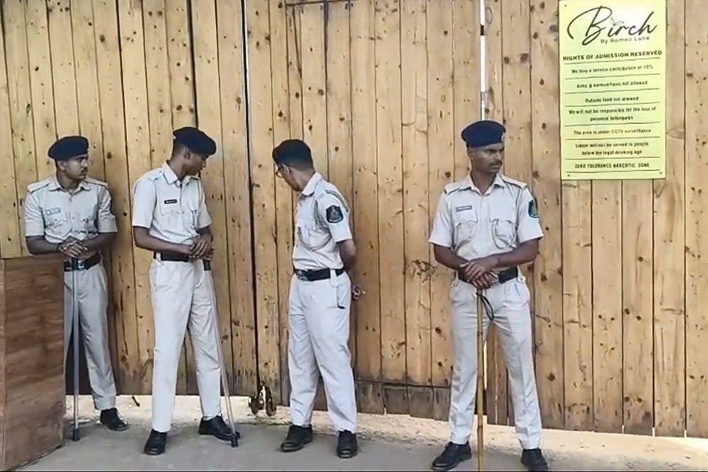 Photo: PTI :  Police personnel keep vigil at the site after a fire broke out at a nightclub due to a cylinder blast, in North Goa. At least 23 people were killed in the incident, according to officials. 