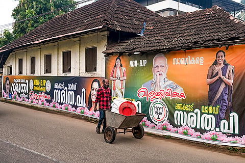 Party banners put up on walls of a house amid preparations for the upcoming Kerala local body polls, in Thiruvananthapuram.