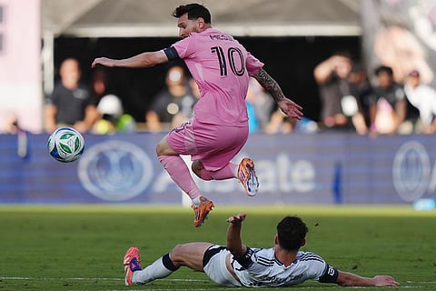 Inter Miami's Lionel Messi (10) leaps over Vancouver Whitecaps' Sebastian Berhalter (16) during the second half of the MLS Cup final soccer match, in Fort Lauderdale, Fla.
