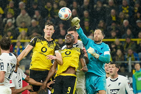 Borussia's Nico Schlotterbeck, top left, abd Serhou Guirassy, centre, challenge for the ball with Hoffenheim's goalkeeper Oliver Baumann during Germany Bundesliga soccer match between Borussia Dortmund and TSG 1899 Hoffenheim, in Dortmund, Germany.