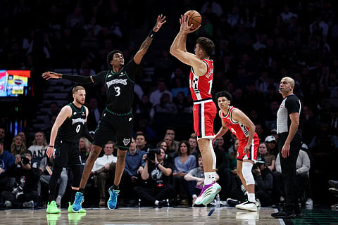 Los Angeles Clippers guard Bogdan Bogdanovic, right, shoots the ball as Minnesota Timberwolves forward Jaden McDaniels (3) defends during the first half of an NBA basketball game in Minneapolis.