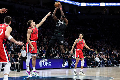 Minnesota Timberwolves guard Anthony Edwards (5) shoots the ball as Los Angeles Clippers guard Bogdan Bogdanovic (10) defends during the first half of an NBA basketball game in Minneapolis.