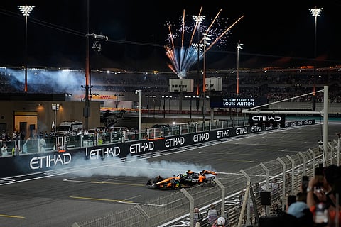 Third placed, new Formula One World Champion McLaren driver Lando Norris of Britain burns tires after the Formula One Abu Dhabi Grand Prix at the Yas Marina Circuit in Abu Dhabi, UAE.