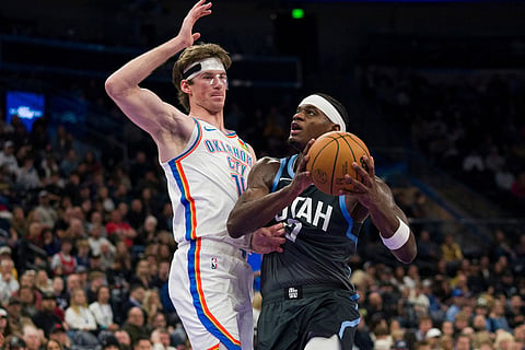 Utah Jazz forward Taylor Hendricks, right, drives to the basket as Oklahoma City Thunder center Branden Carlson defends during the second half of an NBA basketball game in Salt Lake City.