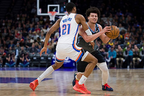 Oklahoma City Thunder guard Aaron Wiggins (21) defends Utah Jazz guard Walter Clayton Jr., right, as he tries to drive to the basket during the second half of an NBA basketball game in Salt Lake City.
