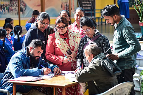 Booth Level Officers (BLOs) collect enumeration forms from voters during the ongoing Special Intensive Revision (SIR) of electoral rolls, in Prayagraj.