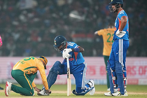 South Africa's Kwena Maphaka, ties the shoe laces of India's Hardik Pandya during the first T20 International cricket match between India and South Africa in Cuttack, India.