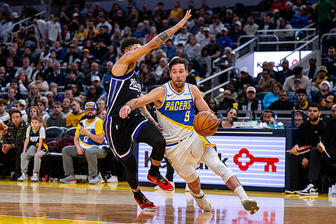 Indiana Pacers guard T.J. McConnell (9) drives along the baseline while being defended by Sacramento Kings guard Nique Clifford during the second half of an NBA basketball game in Indianapolis.