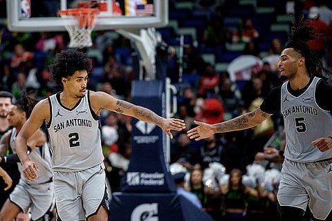 San Antonio Spurs guard Dylan Harper (2) celebrates with San Antonio Spurs guard De'Aaron Fox (4) during the first half of an NBA basketball game against the New Orleans Pelicans in New Orleans.