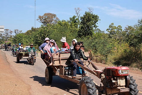 In this photo released by Agence Kampuchea Press (AKP), Cambodian villagers sit on tractors as they flee from the home in Preah Vihear province, Cambodia.