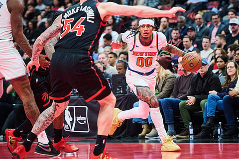 New York Knicks' Jordan Clarkson (00) drives towards Toronto Raptors' Sandro Mamukelashvili (54) during the second half of an NBA Cup basketball game in Toronto.