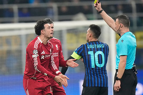 Liverpool's Curtis Jones reacts after being booked by referee Felix Zwayer during a Champions League, league phase, soccer match between Inter Milan and Liverpool in Milan, Italy.