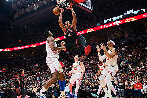 Toronto Raptors' Scottie Barnes (4) dunks as New York Knicks' Josh Hart (3), right, reacts during the first half of an NBA Cup basketball game in Toronto.