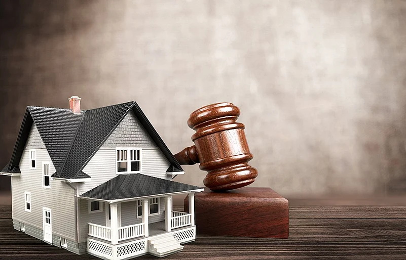 House model with judge’s gavel symbolizing real estate law and property disputes
