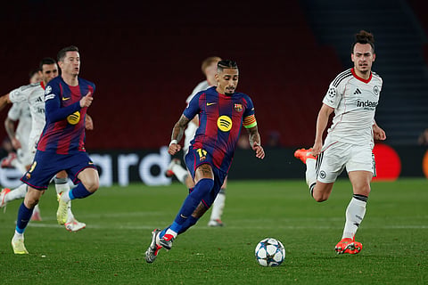 Barcelona's Raphinha centre run with the ball ahead of Frankfurt's Arthur Theate, right, during the Champions League opening phase soccer match between Barcelona and Eintracht Frankfurt in Barcelona, Spain.