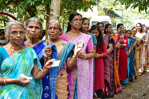 Voters wait in a queue to cast votes during the second phase of the Kerala local body elections, in Thrissur, Kerala.